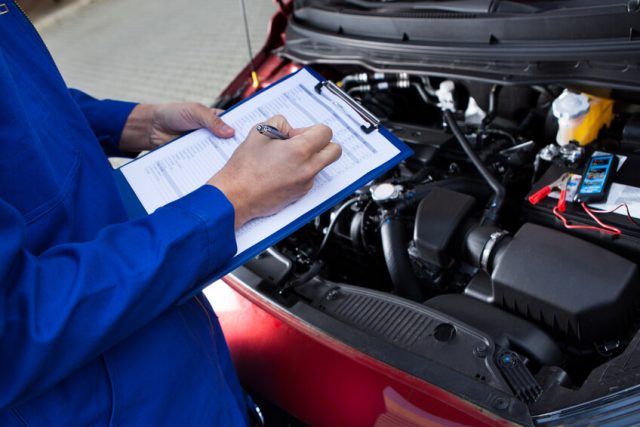 Mechanic inspecting vehicle